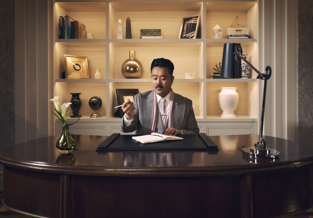 a concierge sitting at their desk holding a pen about to write