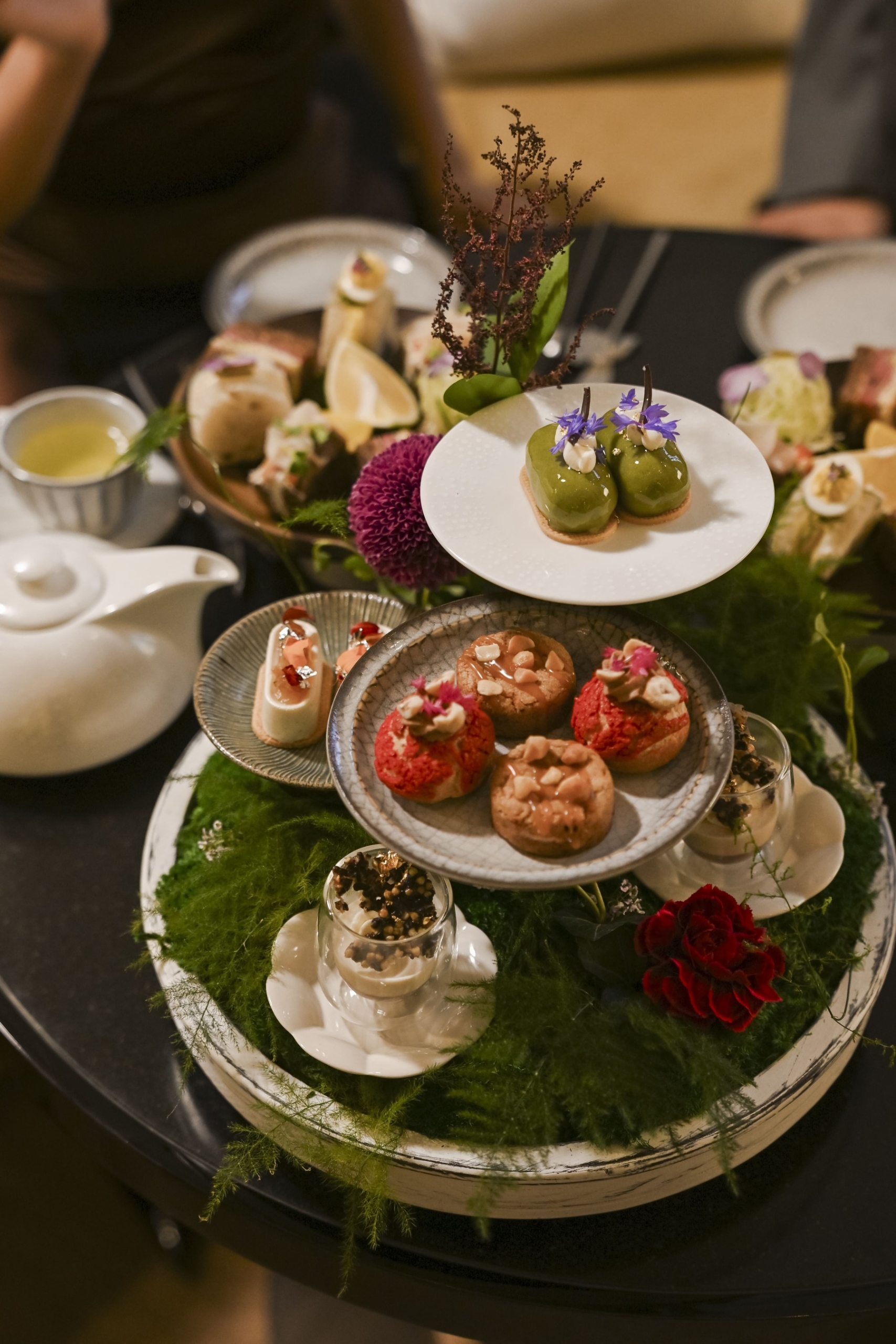 a table full of baked goods in a dim lit setting
