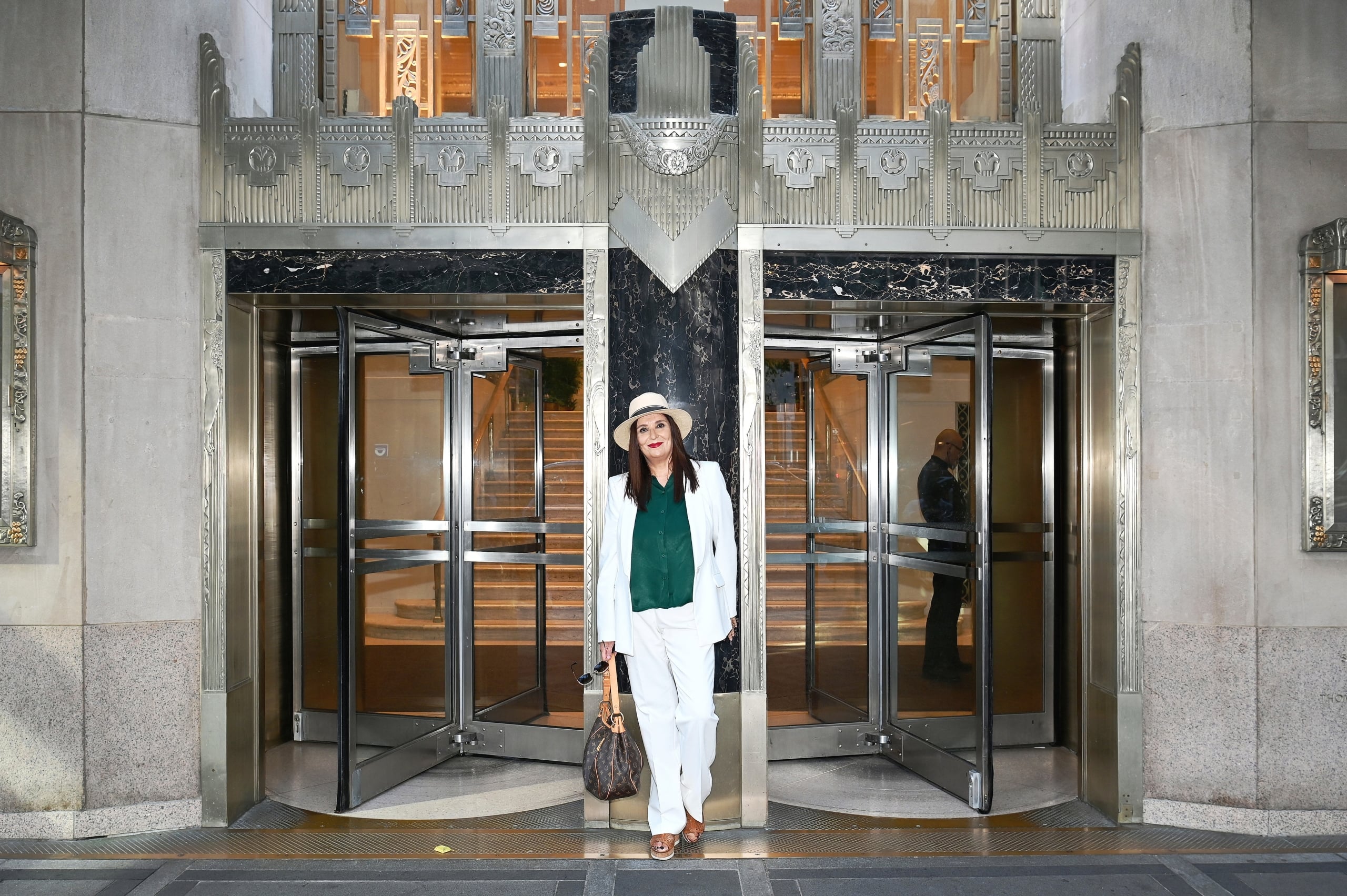 a person standing in the entryway of the hotel wearing a white outfit